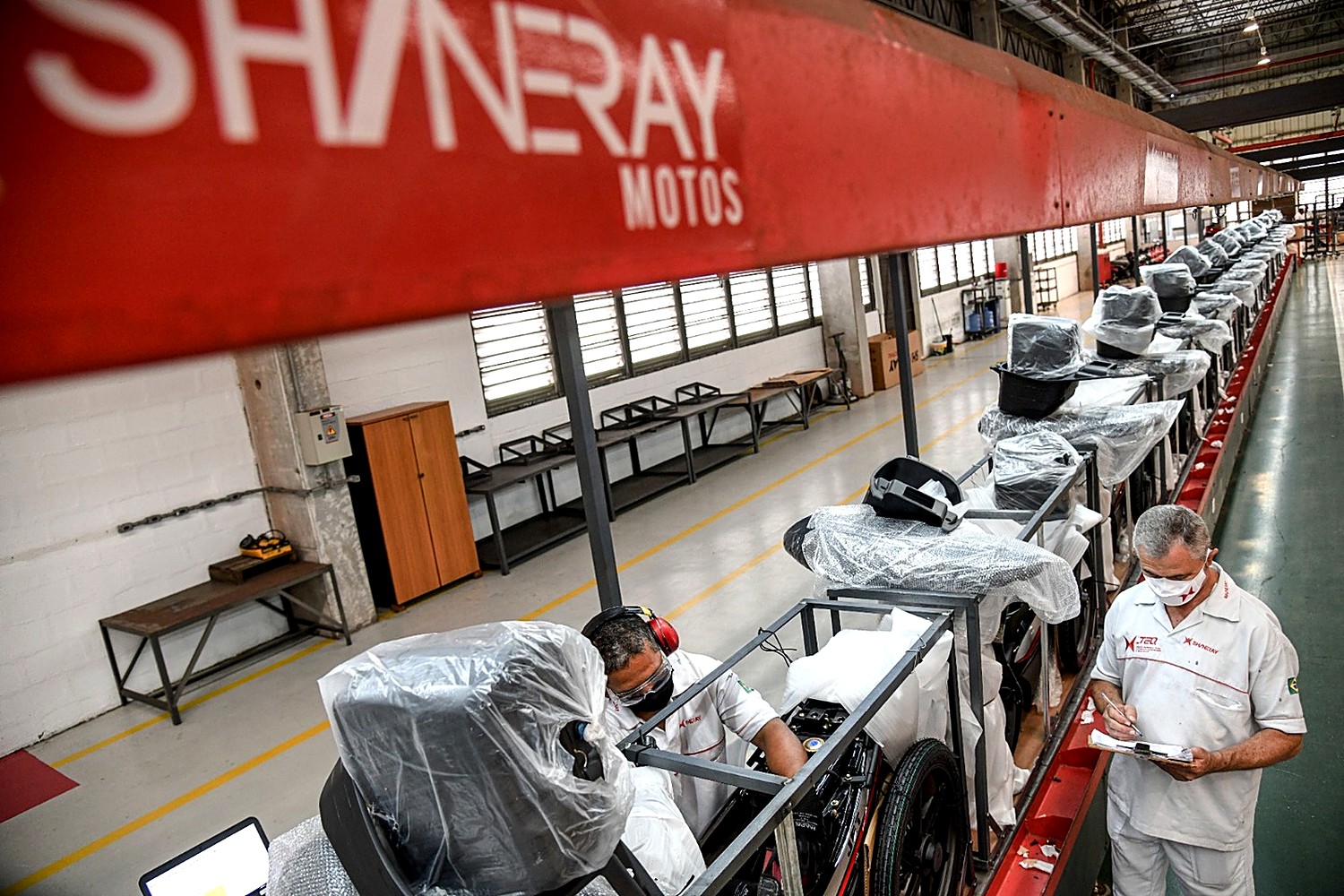 Equipe da Shineray montando motos na linha de produção
